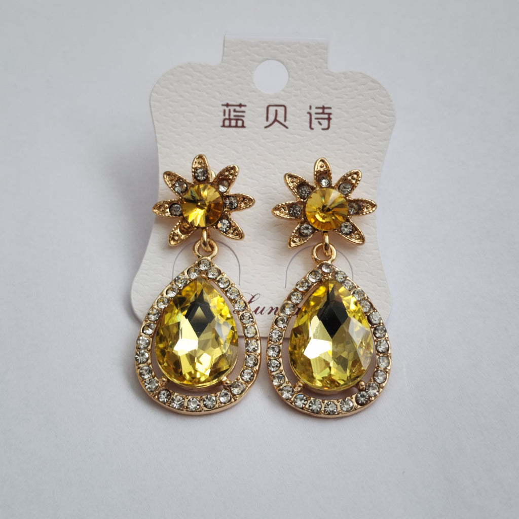 Gold and yellow gemstone earrings on a white card with text