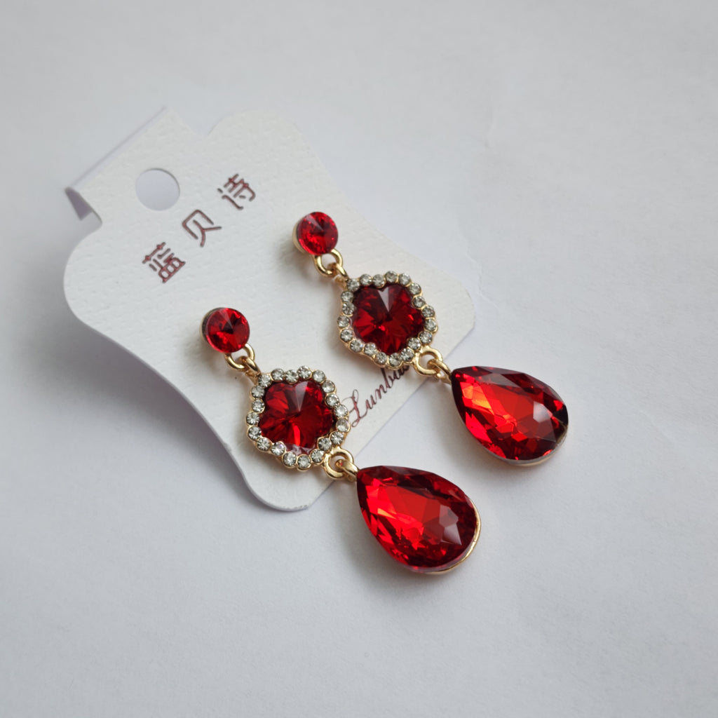 Red teardrop earrings with gold accents on a white background