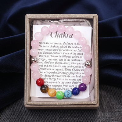 Set of chakra stones in a wooden box with a card on a dark fabric background