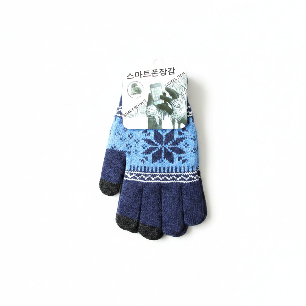 A pair of knit touchscreen gloves in navy blue, light blue, and black, featuring a white snowflake pattern, resting on a light wood floor with a product tag attached.