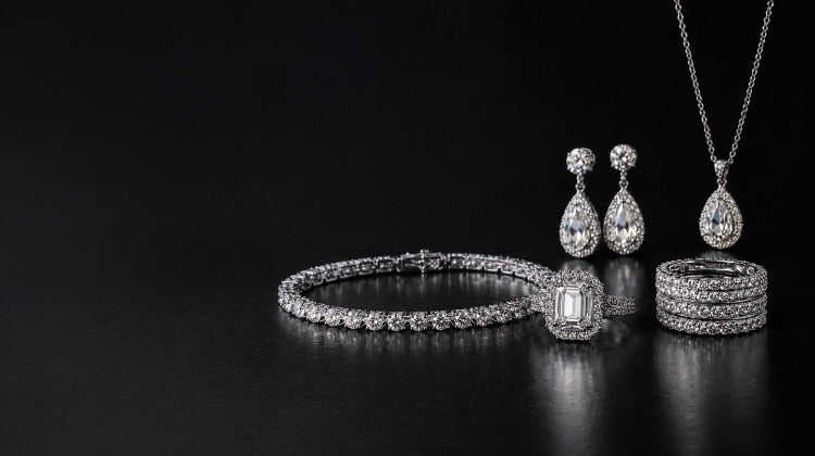 Silver jewelry set including bracelet, earrings, and rings on a black background