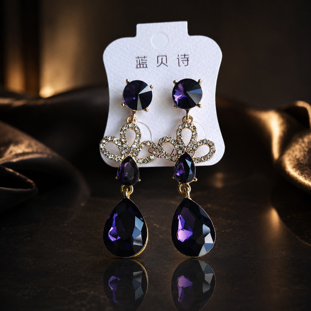 Purple teardrop earrings on a white card with text, against a dark background