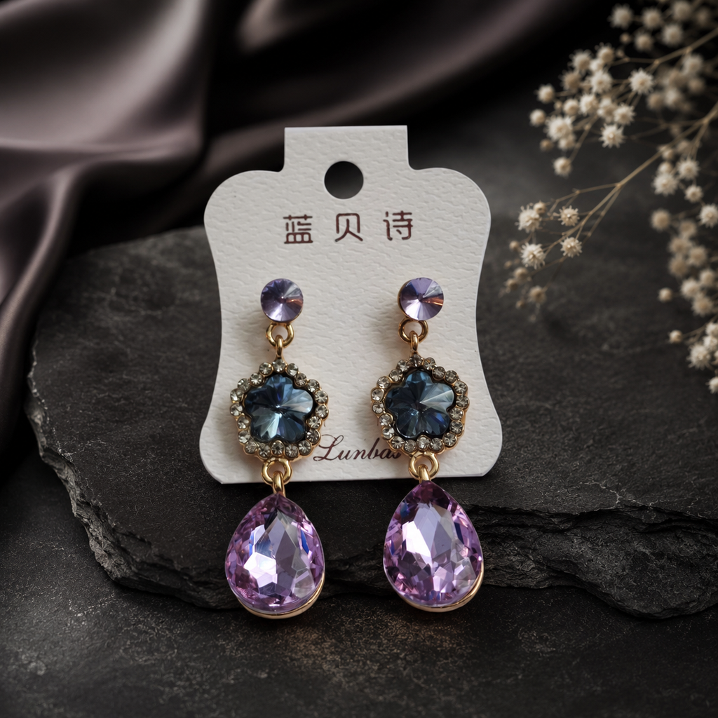 Pair of earrings on a branded card with a dark background